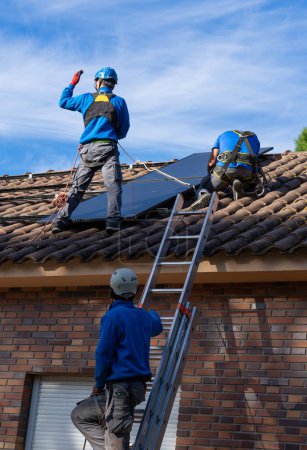Photo for Three workers installing solar panels. Solar energy - Royalty Free Image