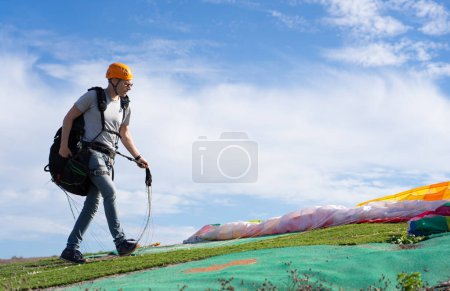 Man preparing paraglider to fly