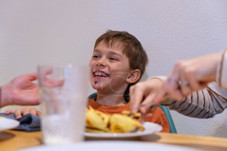Junge frühstückt zu Hause und lächelt