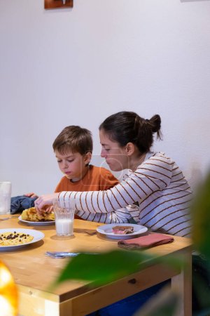 Mother and son having breakfast together at home