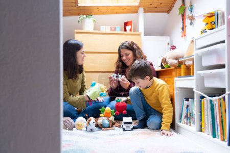 Deux mères lesbiennes jouent avec leur fils dans leur chambre