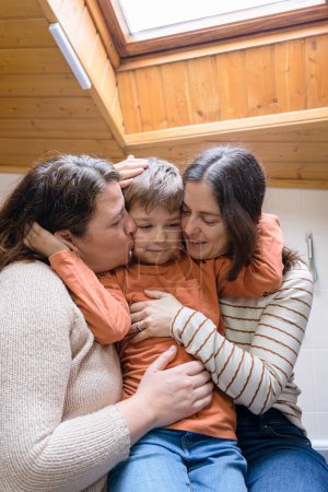 Niño con sus dos madres lesbianas dándose afecto en casa. Familia LGBT