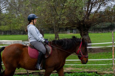 Téléchargez les photos : Femme apprenant à monter à cheval - en image libre de droit