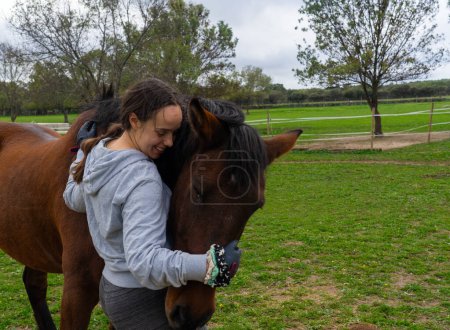 Woman hugging a horse in nature