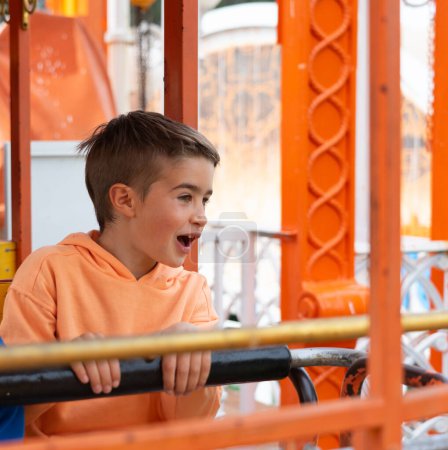 Junge reitet mit kleiner Eisenbahn in Freizeitpark