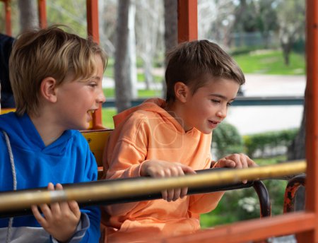 Niños montando una atracción en un parque de atracciones