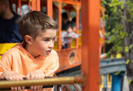 Boy riding a train ride at an amusement park