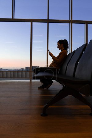 Frau wartet am Flughafen auf ihren Flieger