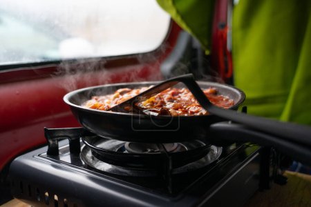 Foto de Sartén cocinando en un gas de camping en una caravana - Imagen libre de derechos