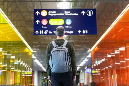 Voyageur regardant un panneau dans un aéroport