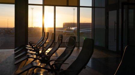 Airport waiting room with a bay window at sunrise