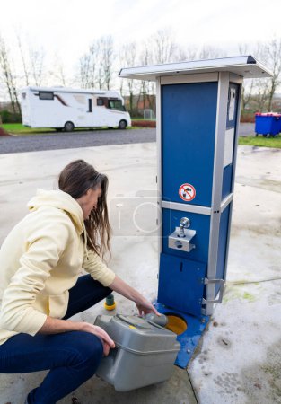 Frau leert Abwasser aus Wohnmobil