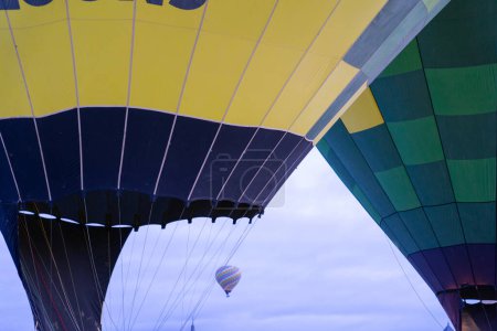 Heißluftballonfestival, bei dem ein Ballon fliegt und andere auf dem Boden liegen