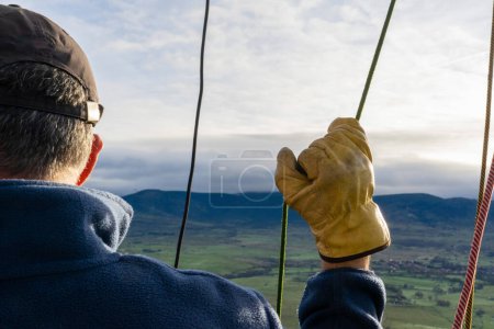 Photo for Hot air balloon pilot piloting a flying balloon seen from close up - Royalty Free Image