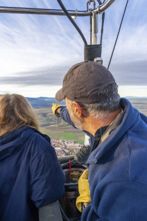 Hot air balloon pilot showing passengers the landscape