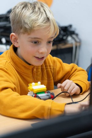 Garçon apprendre la robotique avec un ordinateur