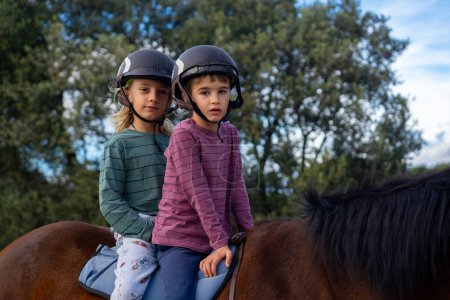 Two children riding a horse together