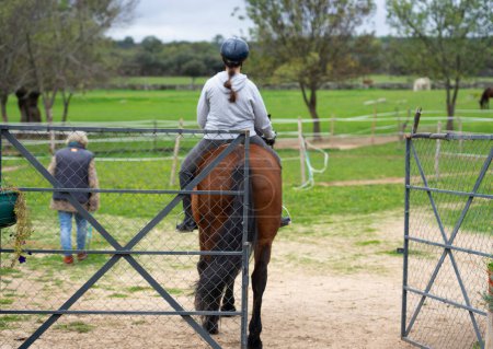 Teenagermädchen in einem Pferdetherapiezentrum auf einem Pferd