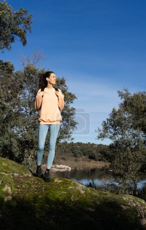 Woman traveling alone on nature hike dressed in peach color