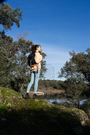 Frau wandert allein mit Rucksack in der Natur
