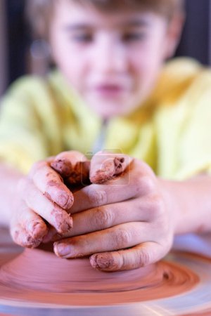 Boy making pottery wheel seen from close up