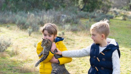 Niños con su gato en la naturaleza