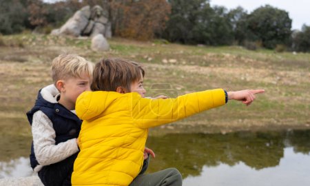 Niños observando la naturaleza en un lago