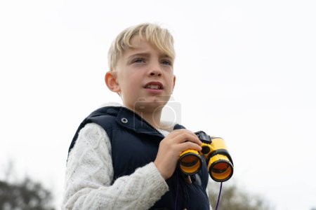 Retrato de niño con prismáticos al aire libre