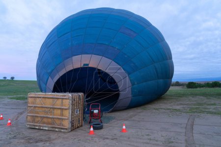 Hot air balloon on the ground, filling with air to fly