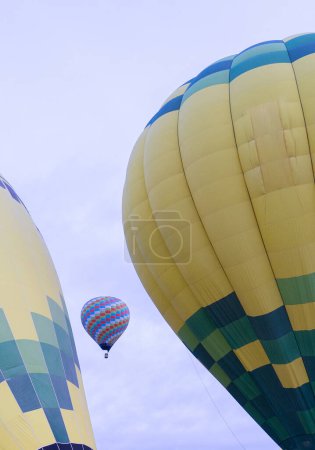 hot air balloons, one flying and others seen from close up