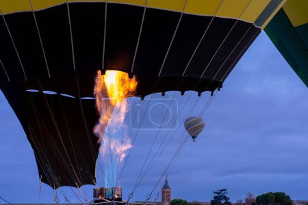 Flamme eines Heißluftballons und ein im Hintergrund fliegender Heißluftballon