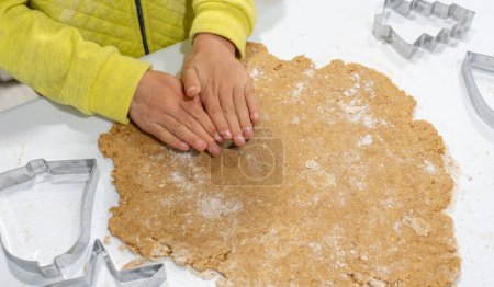 Téléchargez les photos : Mains d'enfant fabriquant des biscuits faits maison avec des moules de forme - en image libre de droit