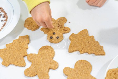 Manos de niño decorando algunas galletas caseras de Navidad