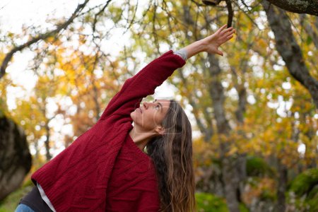 Frau macht Yoga-Pose im Wald