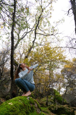 Femme faisant du yoga dans une forêt