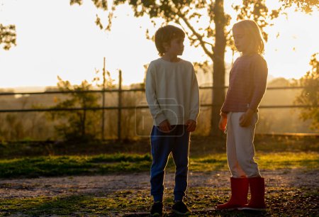Zwei Kinder bei Sonnenuntergang auf dem Feld