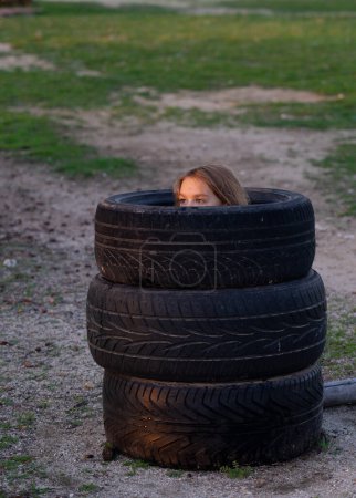 Child hiding inside some tire wheels
