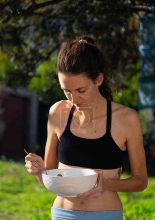 Woman eating a salad outdoors
