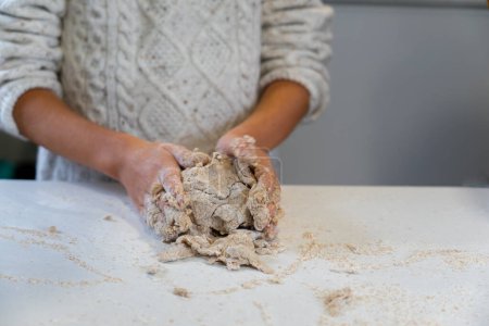 Photo for Child's hands kneading a dough to make bread - Royalty Free Image