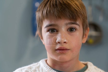 Portrait of child stained with flour because he is cooking a homemade pizza