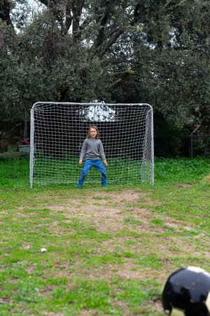Goalkeeper boy playing soccer outdoors