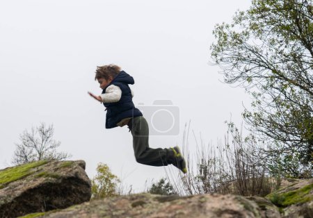 Téléchargez les photos : Enfant sauvage sautant dans la nature - en image libre de droit