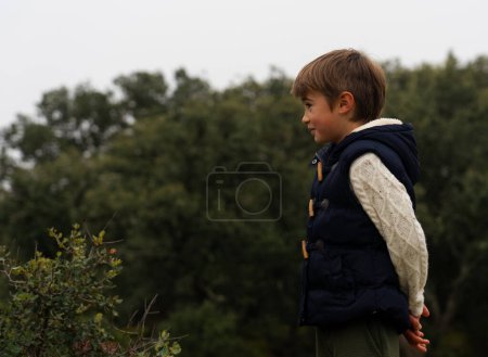 Boy in nature in profile looking at the horizon