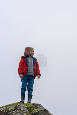 Ein Junge spielt auf dem Feld mit bewölktem Himmel