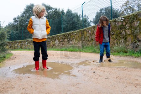 Children jumping in a puddle