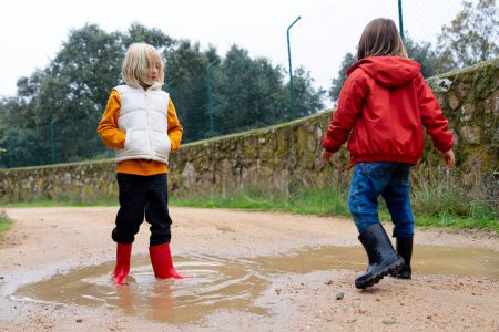 Two children playing in a puddle