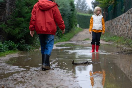 Children playing in puddles outdoors