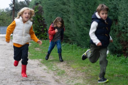 Drei Kinder rennen die Straße hinunter