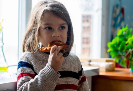 Child eating a pizza at home