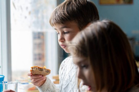 Photo for Children eating pizza together in the kitchen - Royalty Free Image